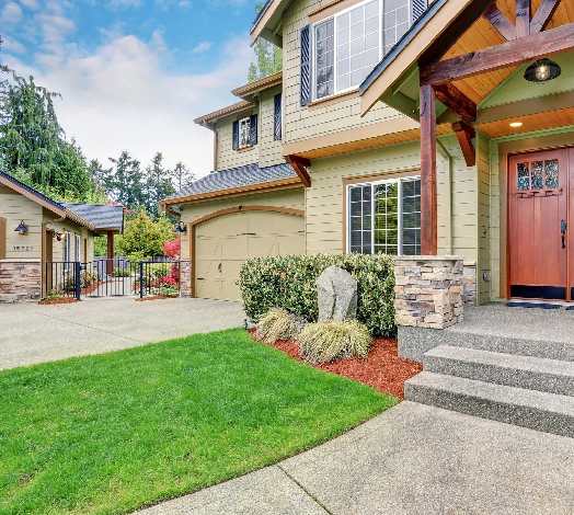 A house with a lawn and steps leading to the front door.